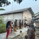 Haru di Lokasi TMMD, Puluhan Ibu dan Anak-anak Turun Tangan Siram Jalan Cor Bersama Satgas TNI